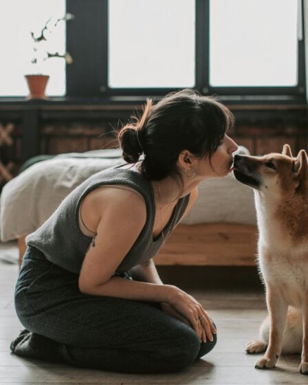 woman sitting on wooden floor with her dog