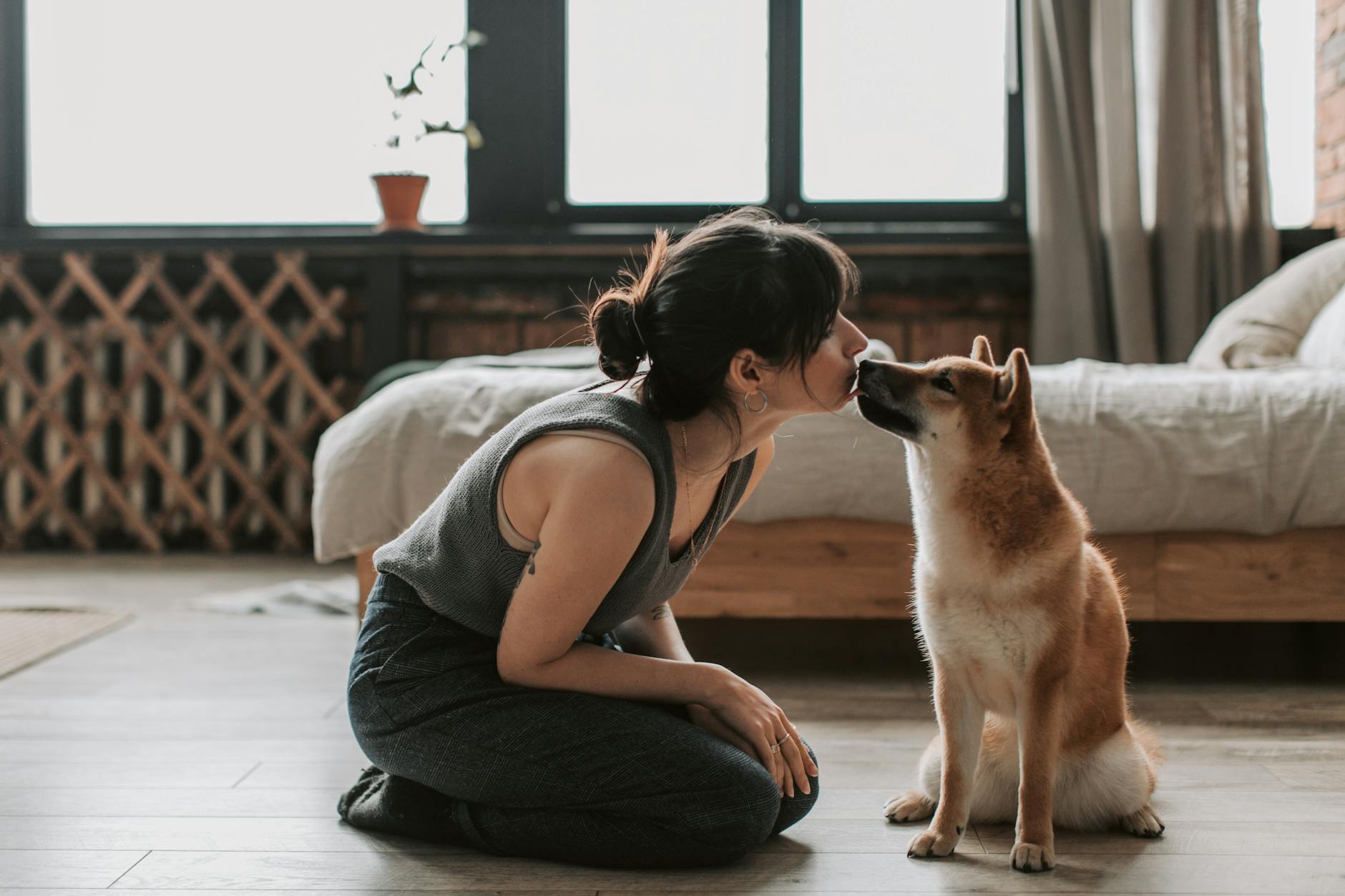 woman sitting on wooden floor with her dog
